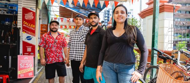 A group of refugees standing and smiling towards camera