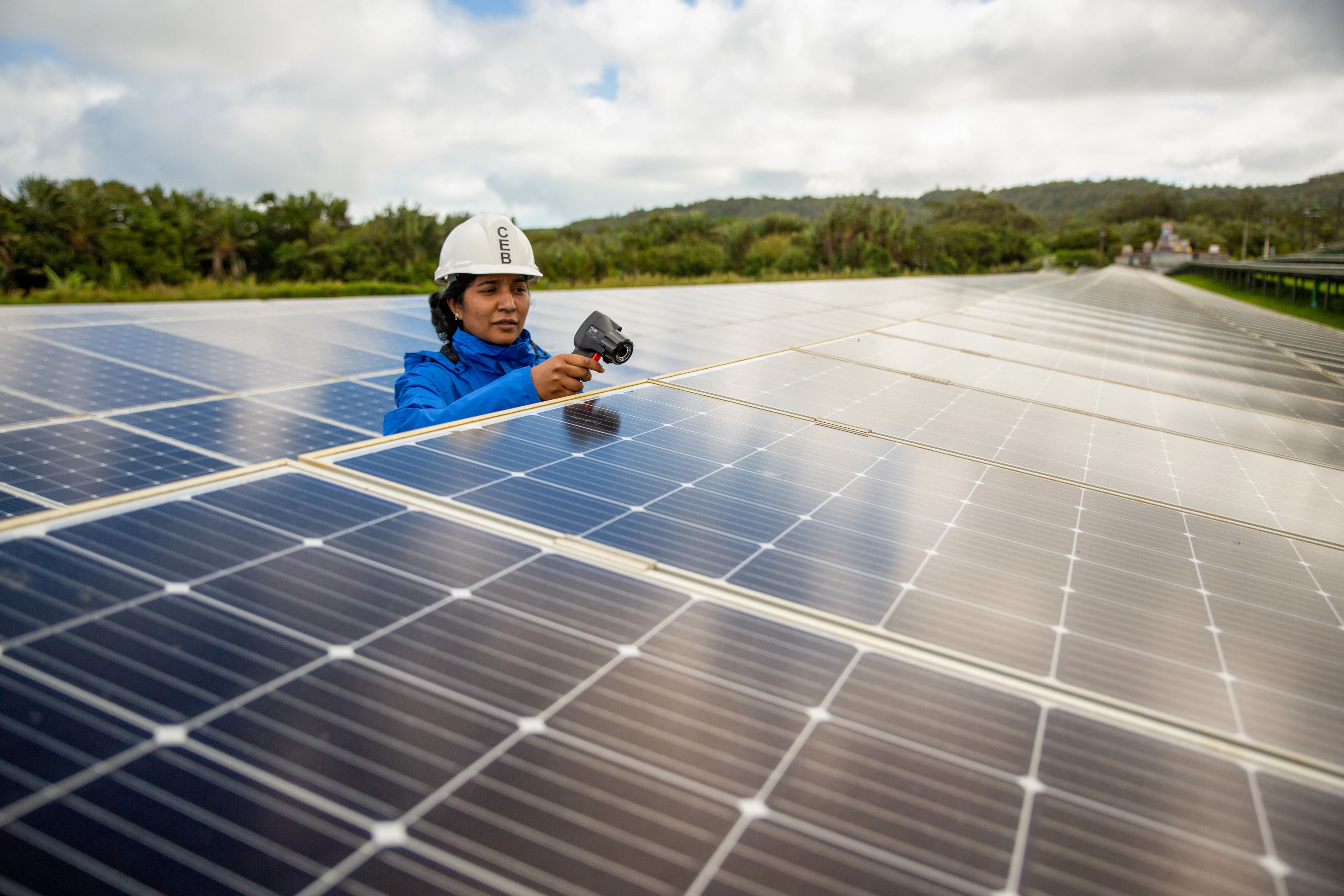 Woman in hard hat works on solar panels