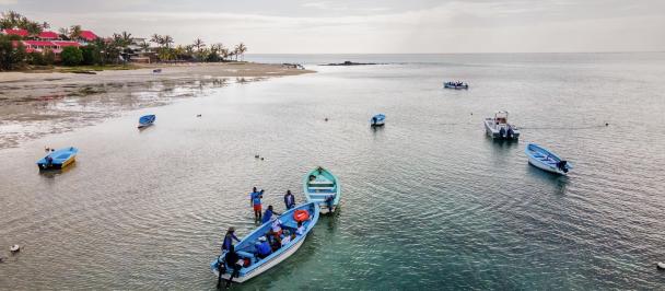 Small boats in ocean near beach