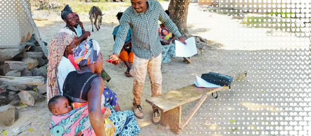 A man speaks with a woman carrying a child on her back